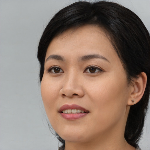 Joyful asian young-adult female with medium  brown hair and brown eyes