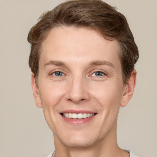 Joyful white adult male with short  brown hair and grey eyes