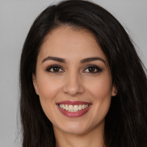 Joyful white young-adult female with long  brown hair and brown eyes