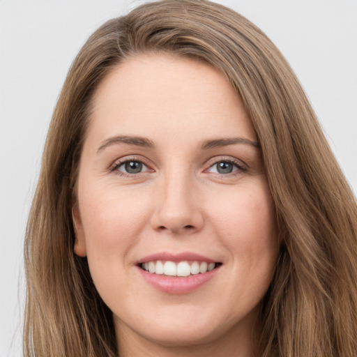 Joyful white young-adult female with long  brown hair and green eyes