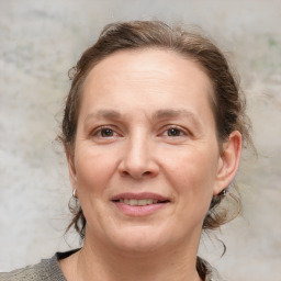 Joyful white adult female with medium  brown hair and brown eyes