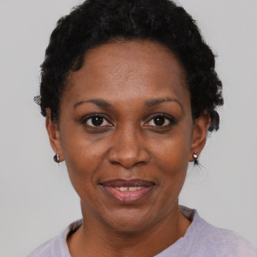 Joyful black adult female with short  black hair and brown eyes