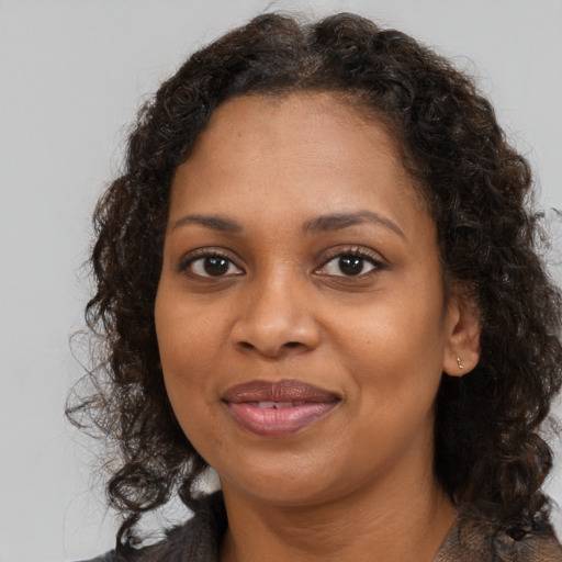 Joyful black adult female with medium  brown hair and brown eyes