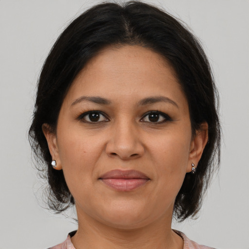 Joyful latino adult female with medium  brown hair and brown eyes