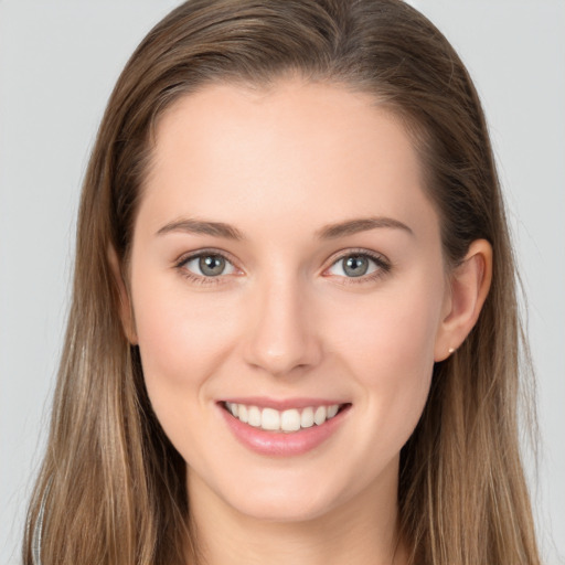 Joyful white young-adult female with long  brown hair and grey eyes