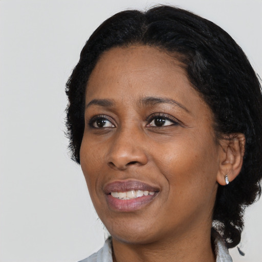 Joyful black adult female with medium  black hair and brown eyes