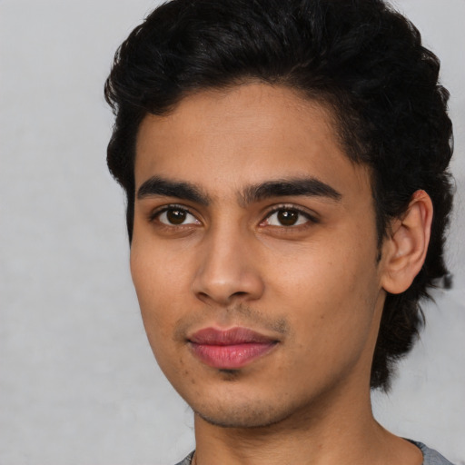 Joyful latino young-adult male with short  brown hair and brown eyes