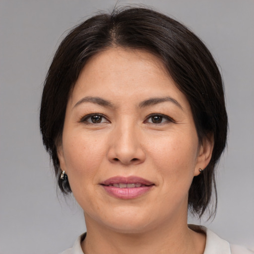 Joyful asian adult female with medium  brown hair and brown eyes