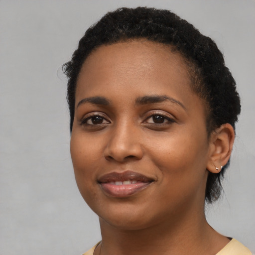 Joyful black young-adult female with medium  brown hair and brown eyes