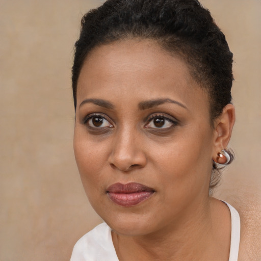 Joyful black young-adult female with short  brown hair and brown eyes