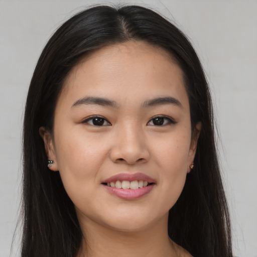 Joyful asian young-adult female with long  brown hair and brown eyes