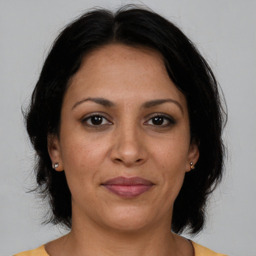 Joyful latino adult female with medium  brown hair and brown eyes