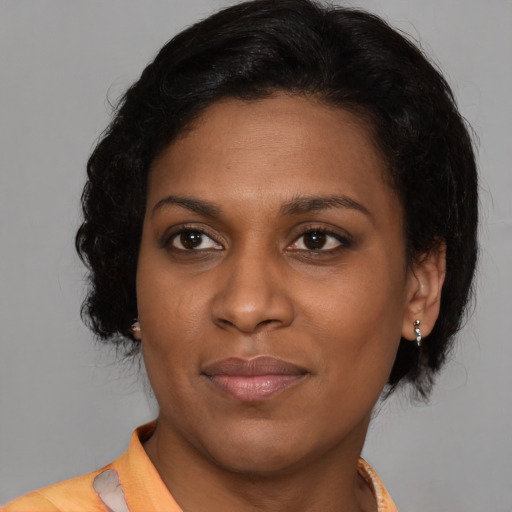 Joyful black young-adult female with medium  brown hair and brown eyes