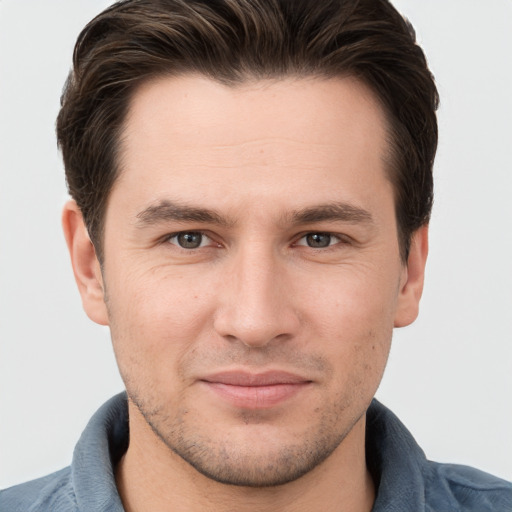 Joyful white young-adult male with short  brown hair and grey eyes