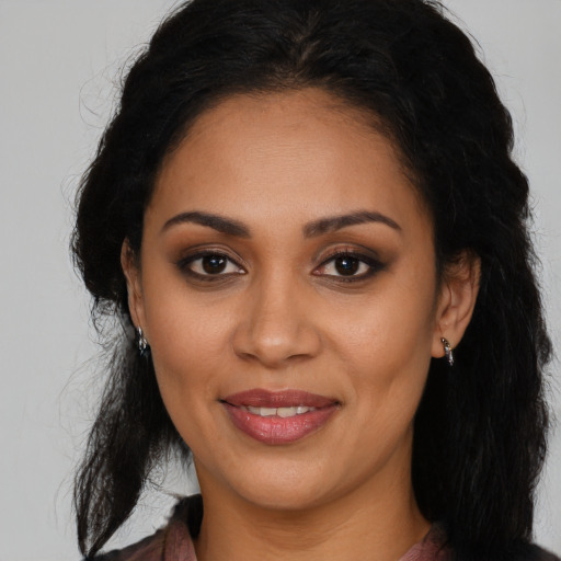 Joyful latino young-adult female with long  brown hair and brown eyes