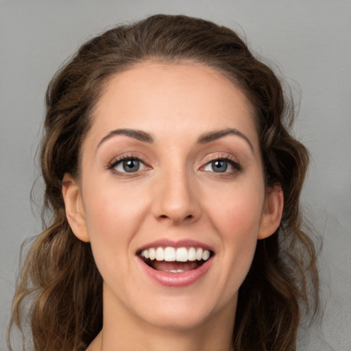 Joyful white young-adult female with long  brown hair and blue eyes