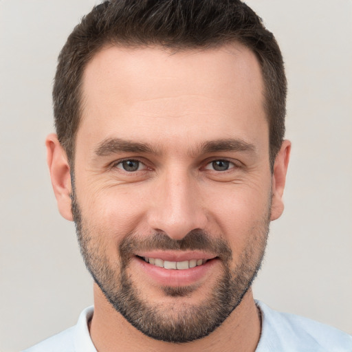 Joyful white young-adult male with short  brown hair and brown eyes