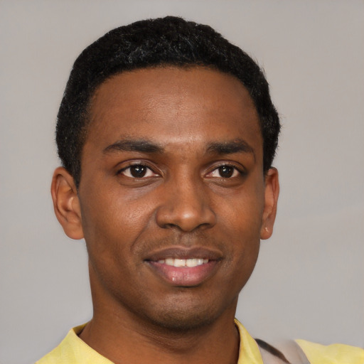 Joyful black young-adult male with short  black hair and brown eyes