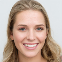 Joyful white young-adult female with long  brown hair and blue eyes