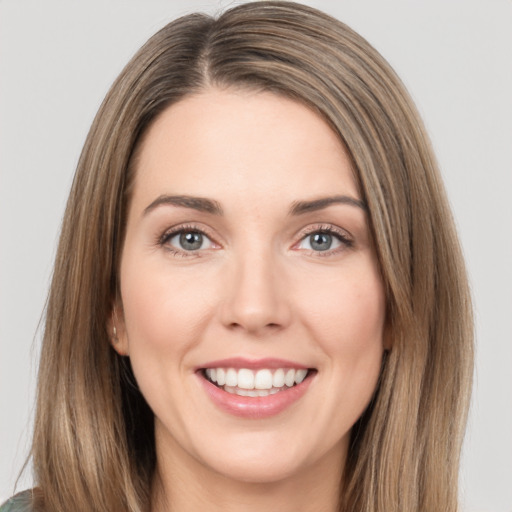 Joyful white young-adult female with long  brown hair and green eyes