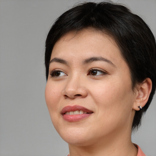 Joyful asian young-adult female with short  brown hair and brown eyes