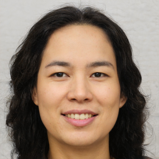 Joyful asian young-adult female with long  brown hair and brown eyes