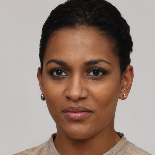 Joyful black young-adult female with short  black hair and brown eyes