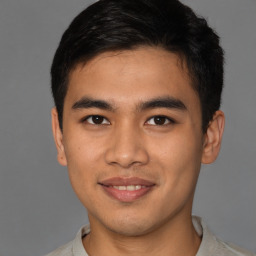 Joyful latino young-adult male with short  brown hair and brown eyes