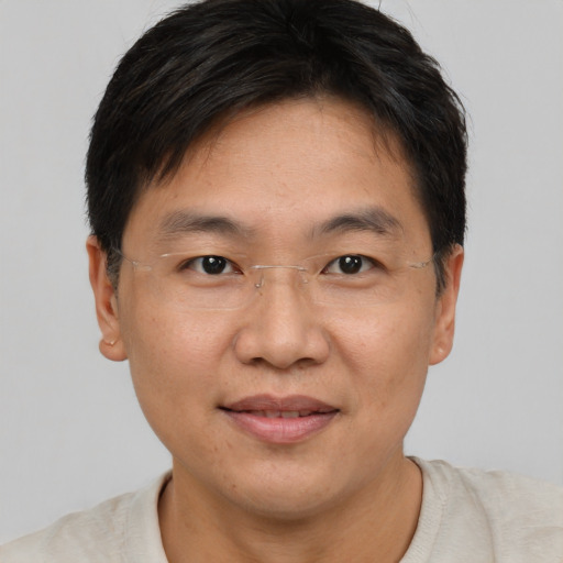 Joyful asian adult male with short  brown hair and brown eyes
