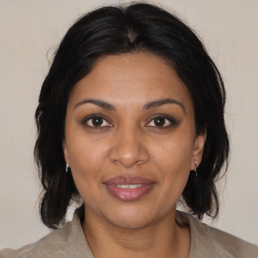 Joyful black adult female with medium  brown hair and brown eyes