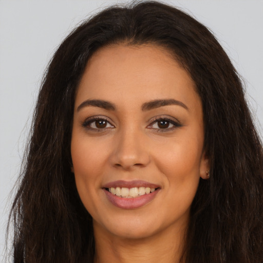 Joyful latino young-adult female with long  brown hair and brown eyes