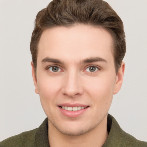 Joyful white young-adult male with short  brown hair and grey eyes