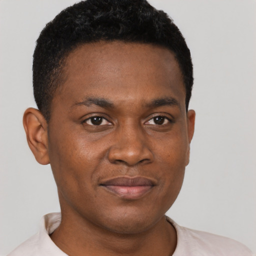 Joyful black young-adult male with short  brown hair and brown eyes