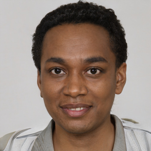Joyful black young-adult male with short  black hair and brown eyes