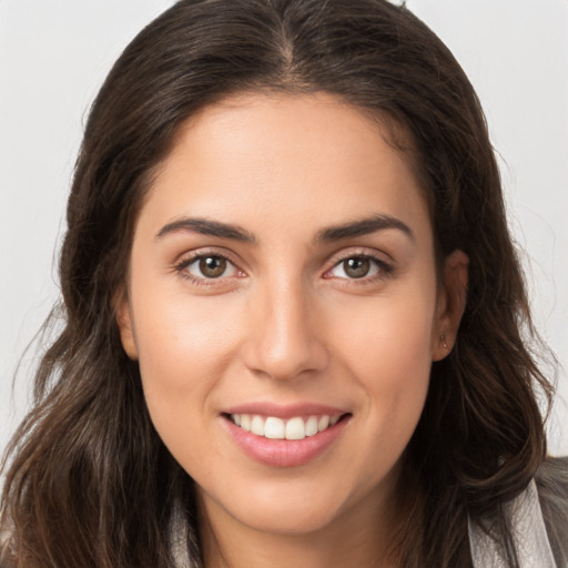 Joyful white young-adult female with long  brown hair and brown eyes