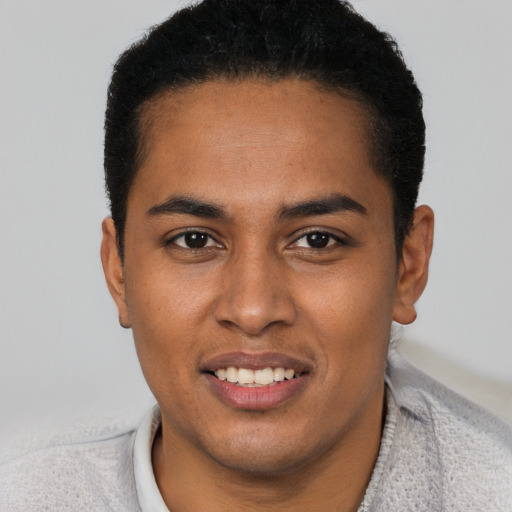 Joyful black young-adult male with short  black hair and brown eyes