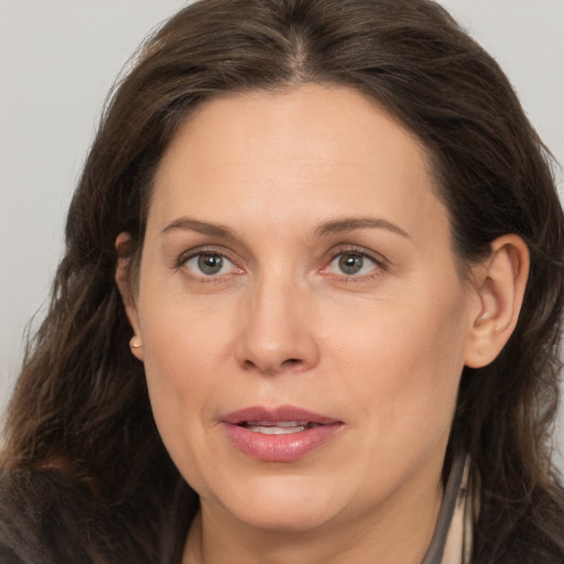 Joyful white adult female with long  brown hair and brown eyes