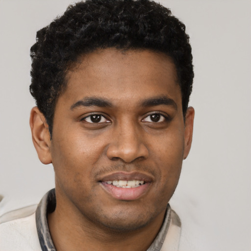 Joyful black young-adult male with short  brown hair and brown eyes