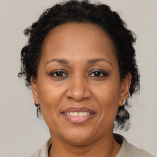 Joyful black adult female with medium  brown hair and brown eyes