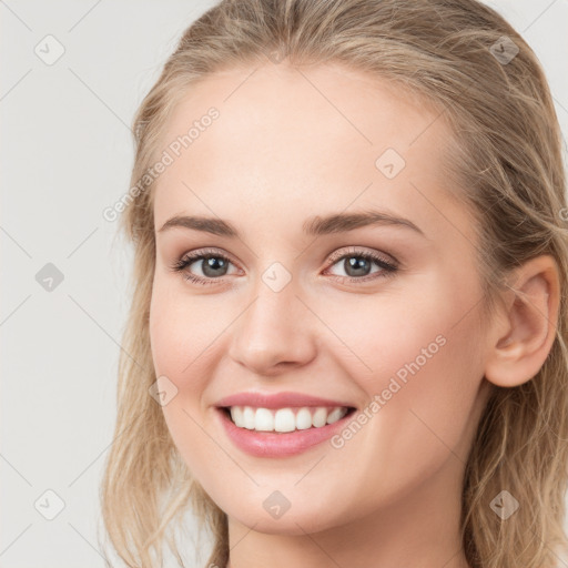 Joyful white young-adult female with long  brown hair and blue eyes