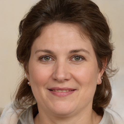 Joyful white adult female with medium  brown hair and grey eyes