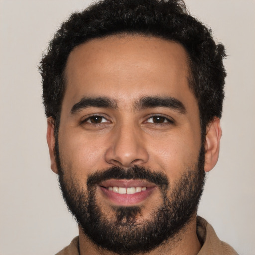 Joyful latino young-adult male with short  black hair and brown eyes