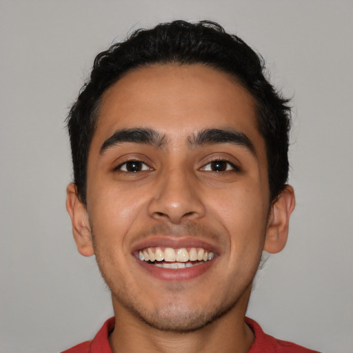 Joyful latino young-adult male with short  black hair and brown eyes