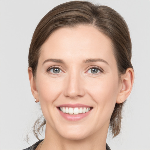 Joyful white young-adult female with medium  brown hair and grey eyes