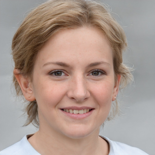 Joyful white young-adult female with medium  brown hair and grey eyes