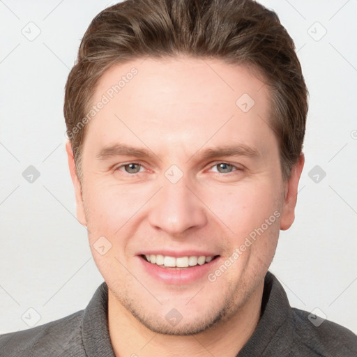 Joyful white young-adult male with short  brown hair and grey eyes