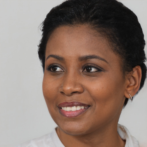 Joyful black young-adult female with short  black hair and brown eyes