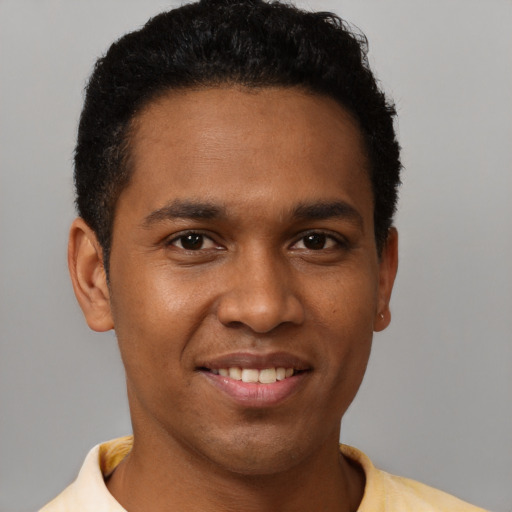 Joyful black young-adult male with short  brown hair and brown eyes