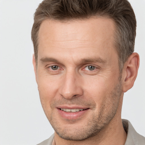 Joyful white adult male with short  brown hair and brown eyes