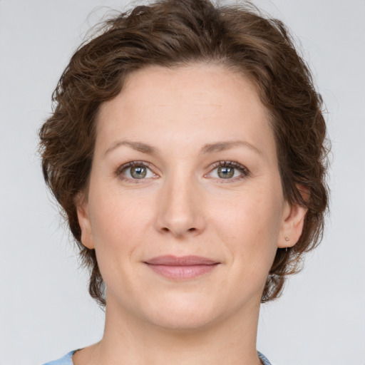 Joyful white young-adult female with medium  brown hair and green eyes